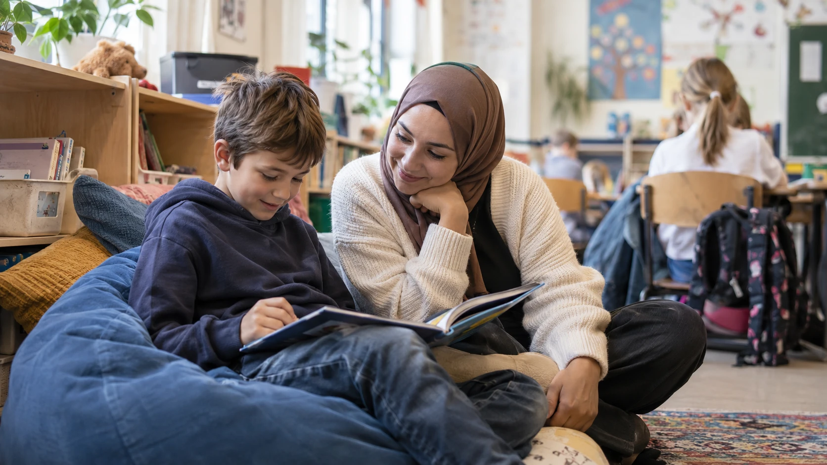 Schulbegleiterin liest mit einem Schüler in der Leseecke der Klasse